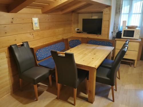 ein Esszimmer mit einem Holztisch und Stühlen in der Unterkunft Entfeldhof - Familie Schernthaner in Fusch an der Glocknerstraße