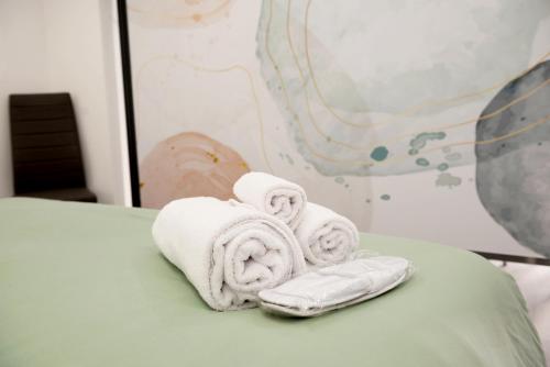 einen Stapel Handtücher auf dem Bett in der Unterkunft San Saba Street Apartment 52 in Rom