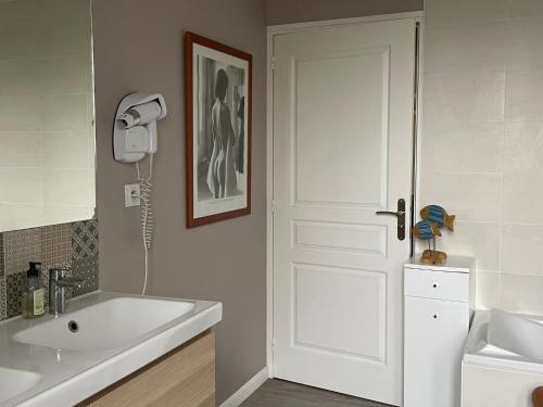 un bagno con lavandino bianco e porta bianca di Gîte Est de la pointe d'Agon 4 convives a Agon Coutainville