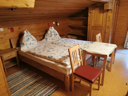 1 dormitorio con 1 cama, mesa y sillas en Entfeldhof - Familie Schernthaner, en Fusch an der Glocknerstrasse