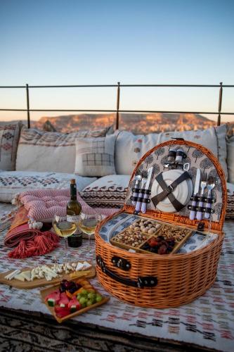 a picnic table with a basket of food and wine at Charming Cave Hotel in Goreme