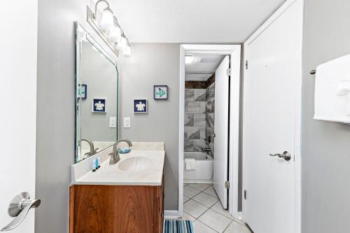 a bathroom with a sink and a mirror at Spacious Seaside Beach and Racquet 3706 with Pool and Comfort Amenities in Orange Beach