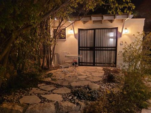 um pátio com uma mesa e cadeiras em frente a um edifício em Bahat's Garden em Kfar Adumim