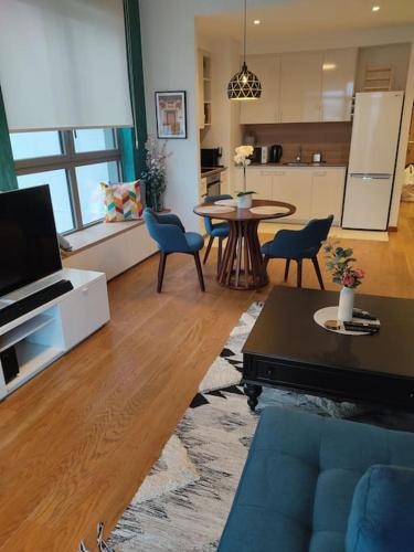 a living room with a blue couch and a kitchen at 2-Bedroom Oasis in the heart of the Waterfront in Sajmište