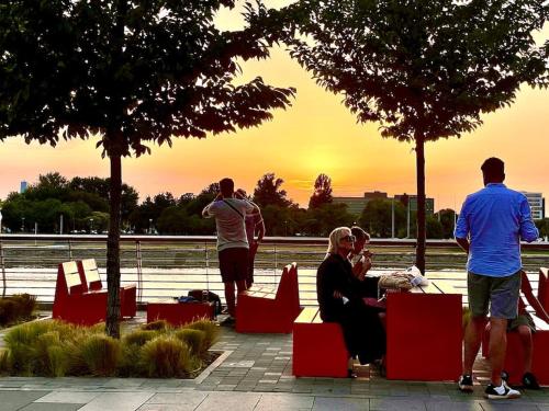 a group of people sitting at a table watching the sunset at 2-Bedroom Oasis in the heart of the Waterfront in Sajmište