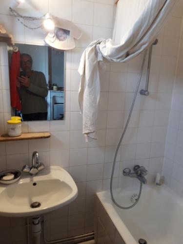 a man taking a picture of a bathroom with a shower at Vue sur les toits de Paris, tour Effeil, centre malakoff, chambre chez l'habitant, sans ascenseur, à deux pas de Paris in Malakoff