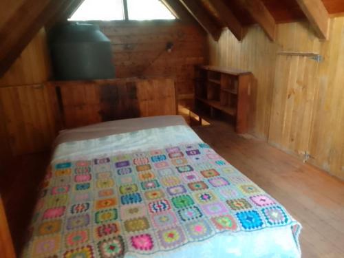 1 dormitorio con 1 cama en una cabaña de madera en San Ignacio en San Carlos de Bariloche