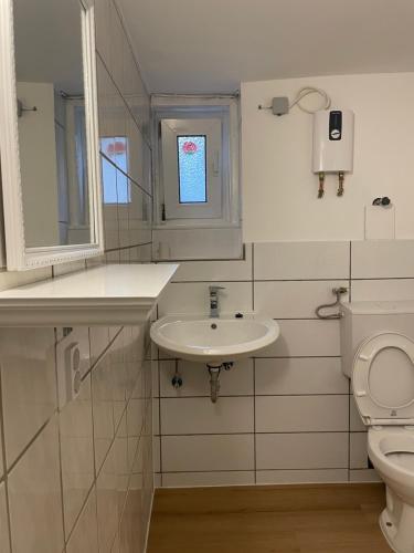 a white bathroom with a sink and a toilet at Unterkunft in Springe Zentrum in Springe
