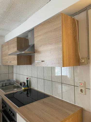 uma cozinha com armários de madeira e um lavatório em Unterkunft in Springe Zentrum em Springe