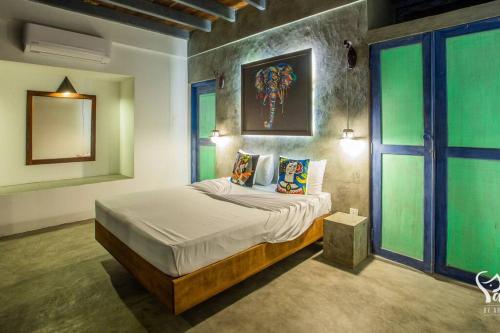 a bedroom with a bed in a room with green walls at Yaal by Aryaana - Villa in Yala in Tissamaharama