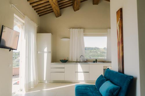 a kitchen with a blue couch and a window at Nontiscordardimé B&B Villa Agriturismo in Civitanova Marche