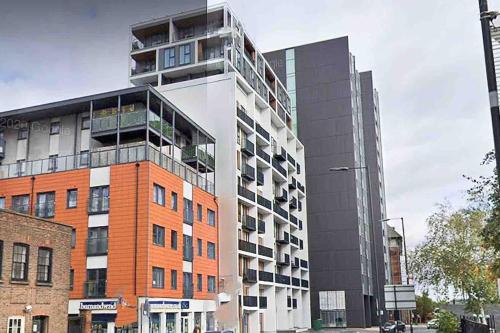 a tall apartment building with a lot of windows at 2 bedrooms flat @ London Sutton Station Zone 5 in Sutton