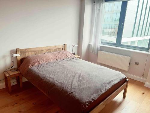 a bed in a bedroom with a large window at 2 bedrooms flat @ London Sutton Station Zone 5 in Sutton