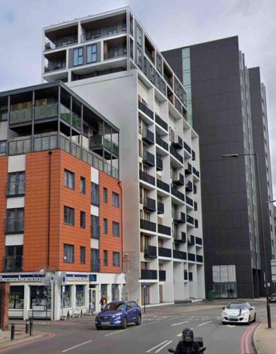 a large building with cars parked in front of it at 2 bedrooms flat @ London Sutton Station Zone 5 in Sutton