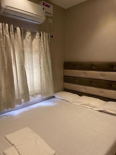 a bedroom with a large bed with a window at AVVAIRAM SERVICE APARTMENT G8 in Chennai
