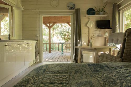 a bedroom with a door leading to a porch with a deck at Chalet Ben in Broek in Benningbroek