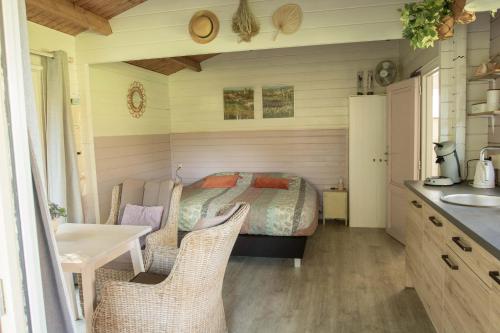 een slaapkamer met een bed en een tafel en stoelen bij Chalet Ben in Broek in Benningbroek