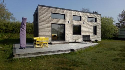 Tiny House sur la cote bretonne في Cléder: منزل به كرسيين وطاولة على السطح