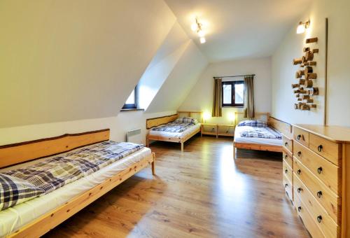 a bedroom with two beds and a wooden floor at Apartmány a chata MONTANUS in Malá Morávka