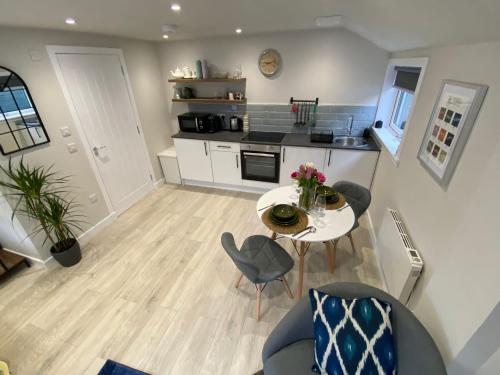 een woonkamer met een tafel en stoelen en een keuken bij Little Rosslyn in Perth