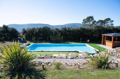 une piscine avec des chaises et un gazebo dans l'établissement Villa 342 m2 classée 4 étoiles sur 1 ha - Provence, à Besse-sur-Issole