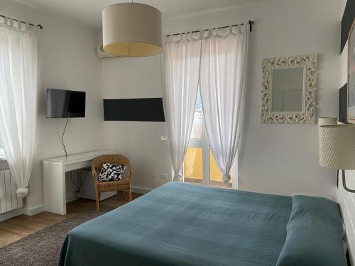 a bedroom with a bed and a desk and a window at Maison Del Magra in Ameglia