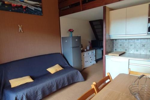 - une cuisine avec un canapé bleu et un réfrigérateur dans l'établissement Duplex gresse-en-vercors, à Gresse-en-Vercors