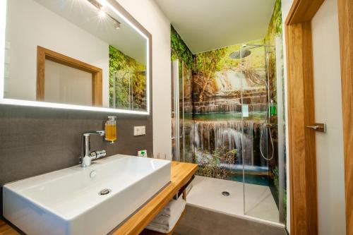 ein Bad mit einem Waschbecken und einer Dusche in der Unterkunft Hotel Landgasthof Oberschnorrhof in Dammbach