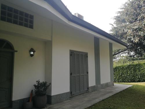 una casa bianca con una porta nera sul lato di Villa in Precollina a Torino