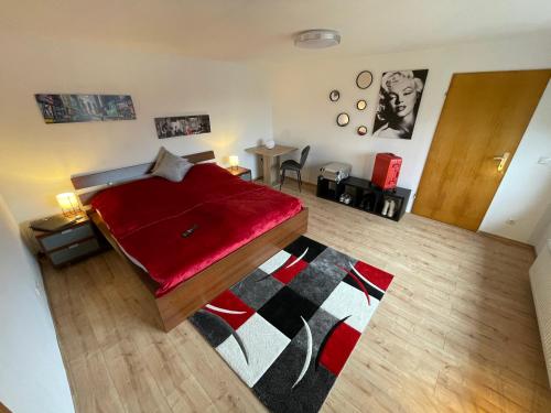 a bedroom with a bed with a red blanket at Ferienhaus Rheinnähe in Lykershausen