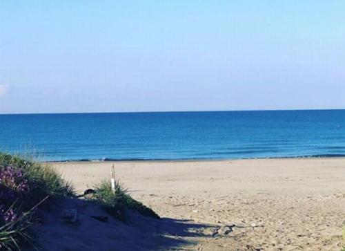 a sandy beach with the ocean in the background at Espo's house in Torvaianica