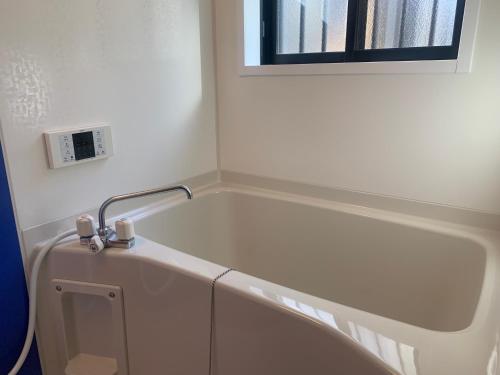 a bath tub in a bathroom with a window at 月兎園 in Yoshioka