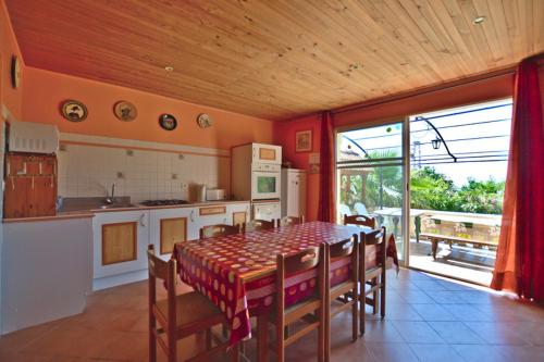 une cuisine et une salle à manger avec une table et des chaises dans l'établissement Maison 9 couchages avec piscine et jardin au calme, à Barbaggio