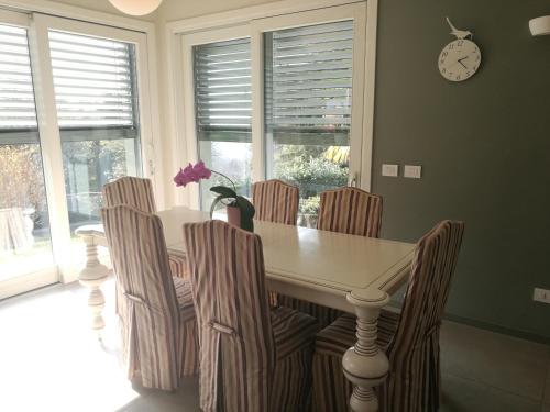 a dining room table with chairs and a clock on the wall at Villa in Precollina in Turin