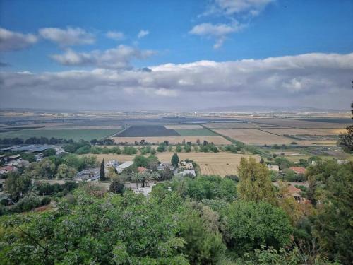 una vista aerea di una città con un lago e alberi di על קצה ההר a Yoqne‘am