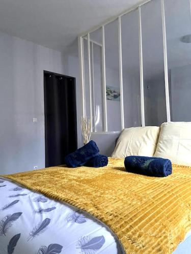 Una cama con almohadas azules encima. en Apartment in the heart of Chinatown, Paris, en París