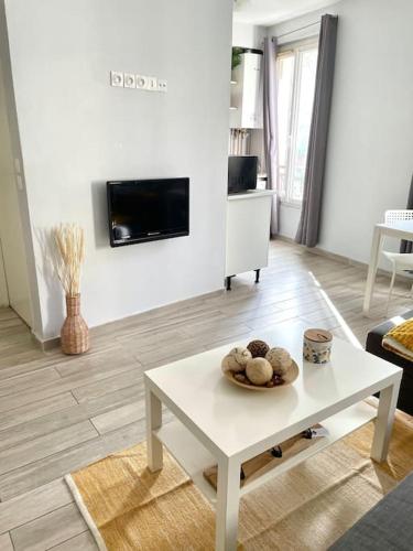 Il comprend un salon doté d'une table blanche et d'une télévision. dans l'établissement Apartment in the heart of Chinatown, Paris, à Paris