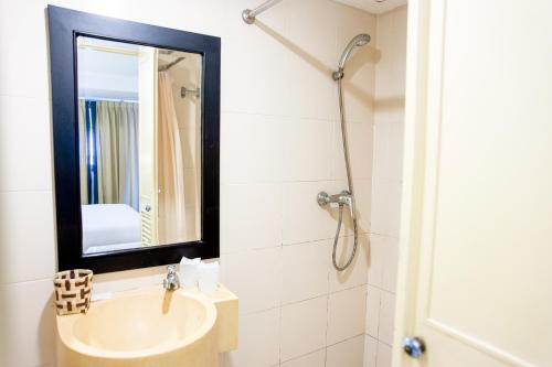een badkamer met een wastafel en een spiegel bij Crystal Inn in Phuket