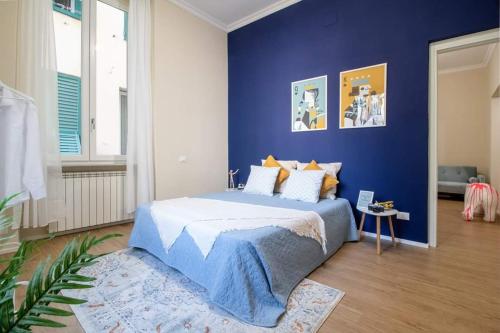una camera da letto con una parete blu e un letto di My Sweet Home a Genova