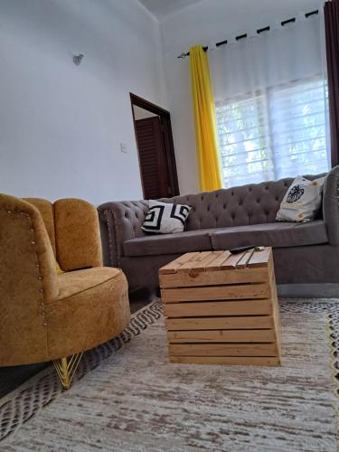 a living room with a couch and a chair at Halisi Stays 1Bed near SGR/Airport Mombasa in Mombasa