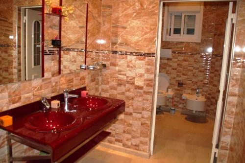 a bathroom with a red sink and a shower at Villa zohour in Marrakesh