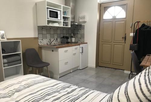 1 dormitorio con 1 cama y cocina con puerta en Studette de 17m2 avec parking privé gratuit Climatisation et petite cuisine, en Menton