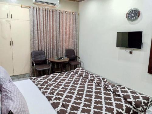 a bedroom with a bed and a table and chairs at Hotel Sky Inn Clifton in Karachi