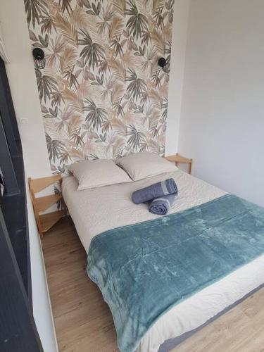 - un petit lit dans une chambre avec un mur dans l'établissement Le Viva, à Saint-Étienne