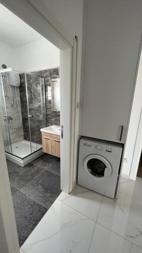 a bathroom with a washing machine and a shower at Tetris Apartment Spacious Comfortable in Lefkosa Turk