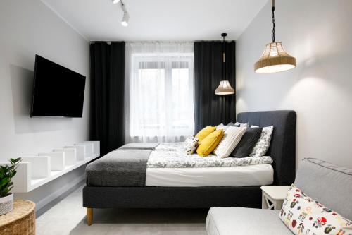 a bedroom with a bed with yellow pillows at Rakowicka 71 Partnerapart in Krakow