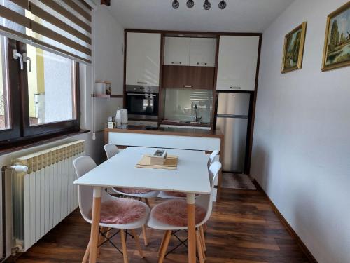 a small kitchen with a white table and chairs at Apartman Kovaci in Sarajevo
