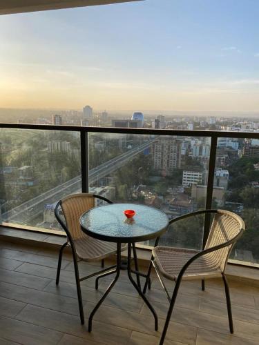 a table and two chairs on a balcony with a view at two bedroom in Westland in Nairobi