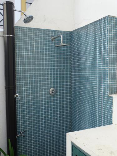Łazienka z prysznicem wyłożona jest niebieskimi kafelkami. w obiekcie BRIGHT AMBIENCE by Stay in Alentejo w mieście Vila Nova de Milfontes