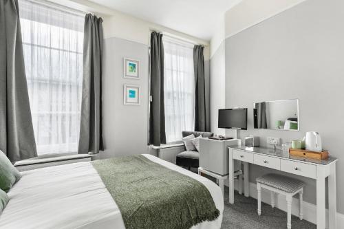 a bedroom with a bed and a desk and a tv at South view in Torquay